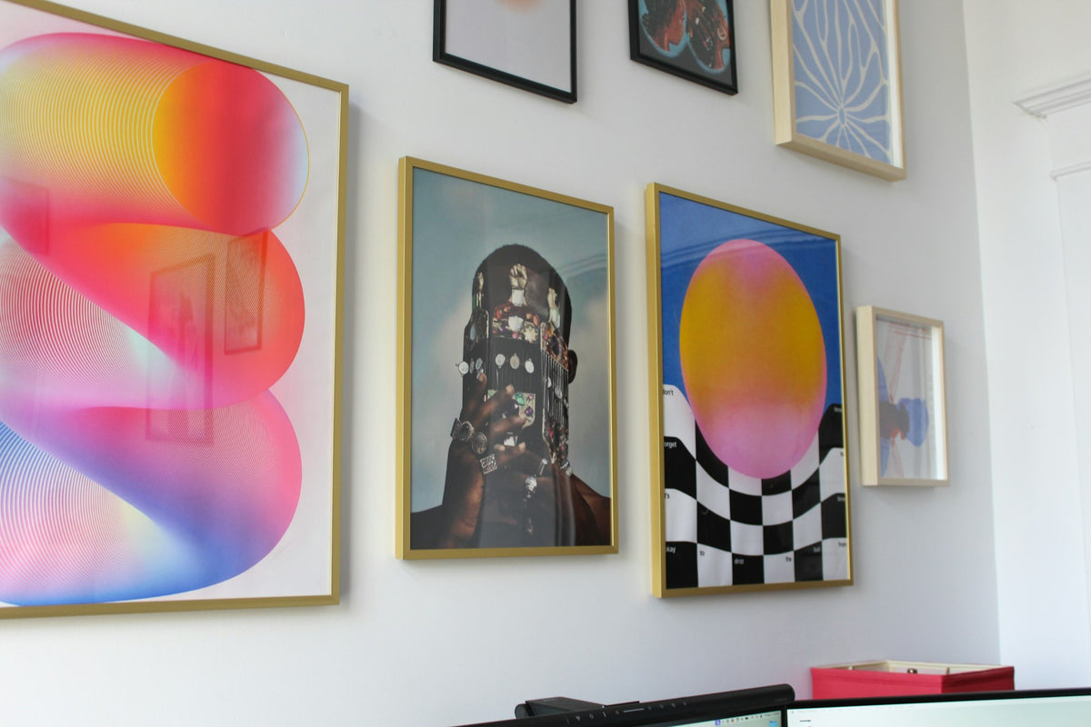 Colourful canvas paintings hanging together on a white wall